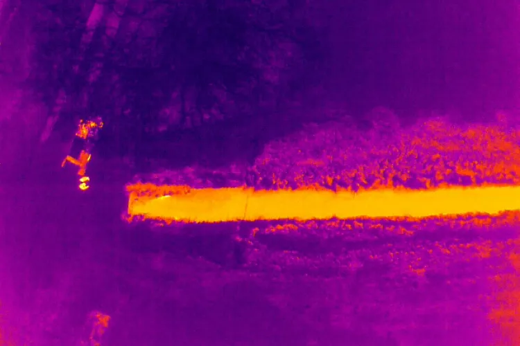 Figuur X; Droneaanzicht met normale camera (links) en met thermische camera (rechts), op een spectrum van paars/blauw (koud) naar oranje/geel (warm)
