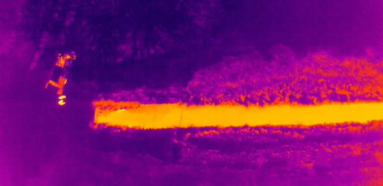 Figuur X; Droneaanzicht met normale camera (links) en met thermische camera (rechts), op een spectrum van paars/blauw (koud) naar oranje/geel (warm)